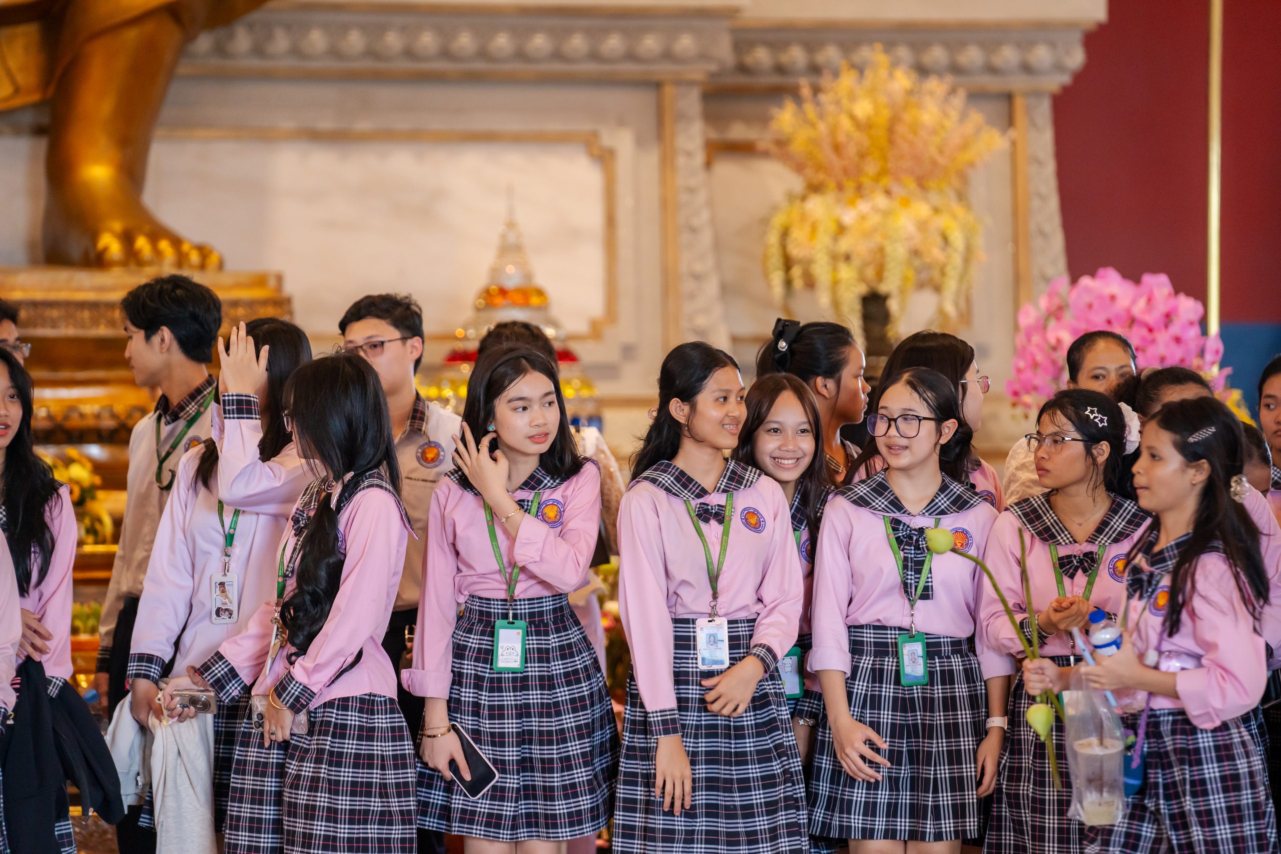 Students making a respectful sampeah gesture at a pagoda