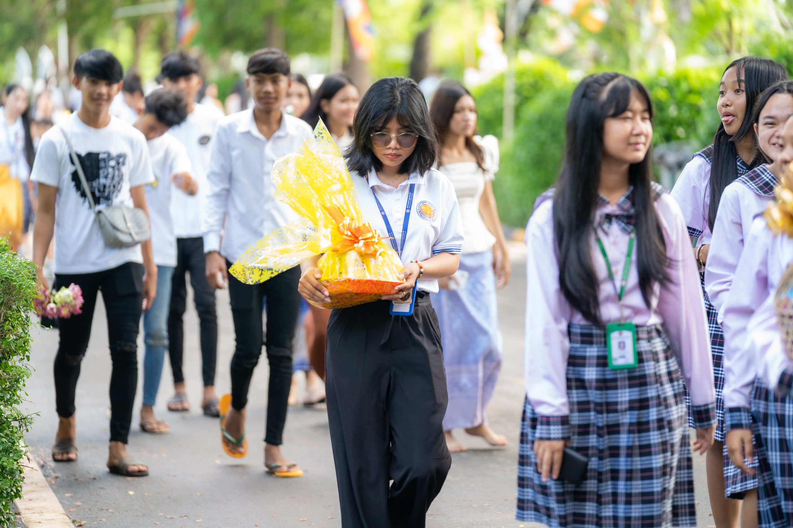 Students carrying offerings while visiting a Cambodian pagoda