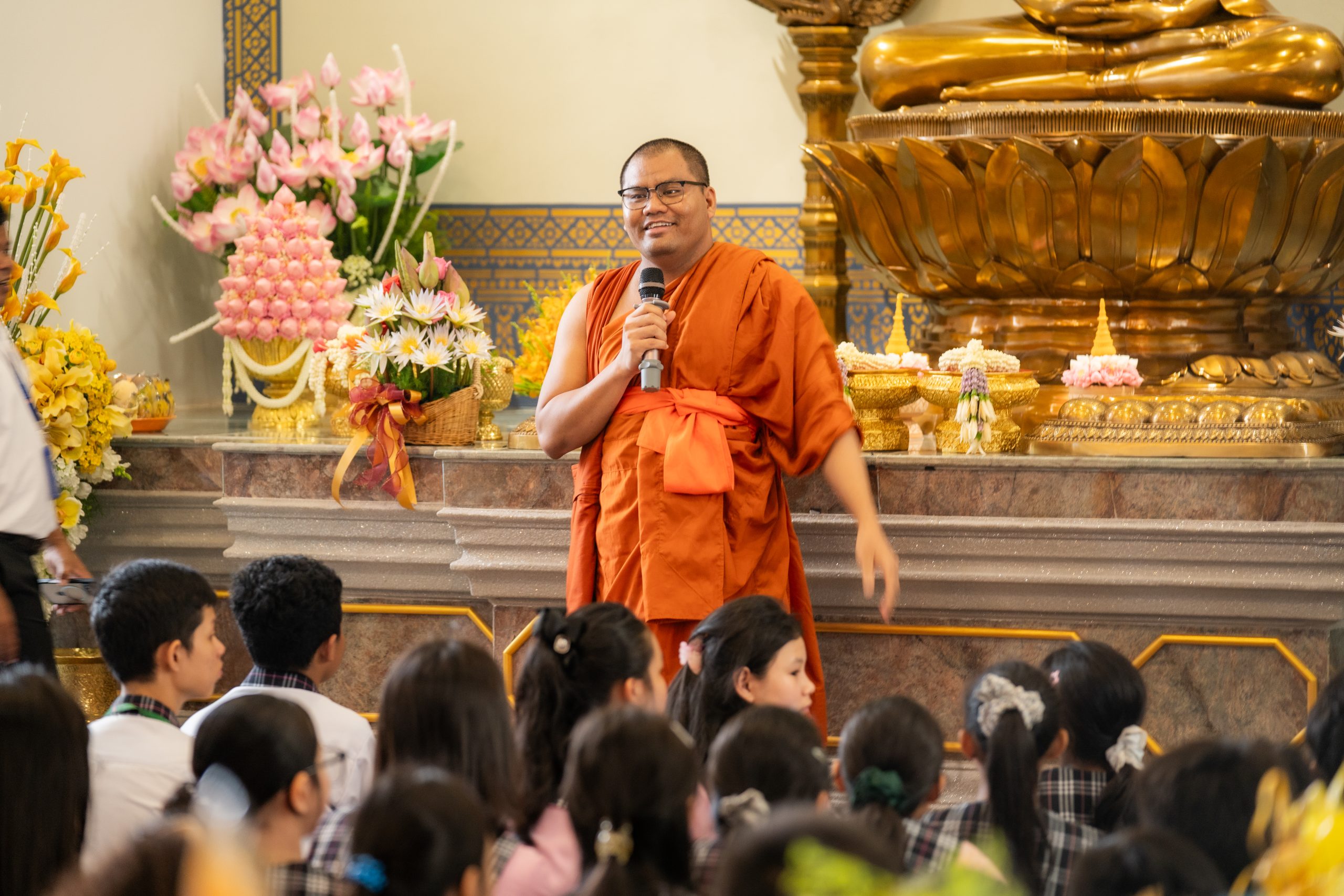 Monk sharing Buddhist teachings with students inside a pagoda